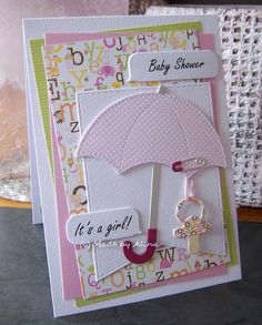 a baby shower card with an umbrella and key hanging from it's front end