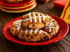 cookies with white icing and chocolate chips on a red plate next to some candy bars