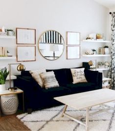 a living room with black couches and white rugs on top of a wooden floor