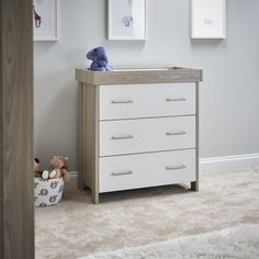 a baby's room with white furniture and pictures on the wall