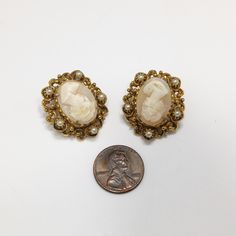 "*Description: This is a beautiful pair of Florenza carved shell earrings in a gold plated filigree frame with small faux pearl accents. The earrings are clip and are signed on the back side of each earring, FLORENZA, with the copyright symbol. These earring \"Ladies\" are each unique and it is obvious they are carved due to the unique features in their faces and the depth of each carving. Each unique cameo is set in gold plated filigree with five faux pearls on each earring. This would be a gre Formal Yellow Gold Cameo Jewelry, Gold Oval Cameo Earrings, Formal Yellow Gold Cameo Earrings, Luxury Yellow Gold Cameo Jewelry, Gold Cameo Earrings For Collectors, Filigree Frame, Copyright Symbol, Formal Earrings, Cameo Earrings