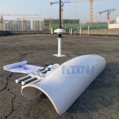 an airplane laying on the ground with construction in the background