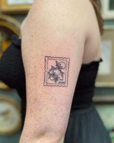 a woman's arm with a stamp on it that has an image of a flower