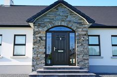 a house with a black front door and steps leading up to the front door is shown