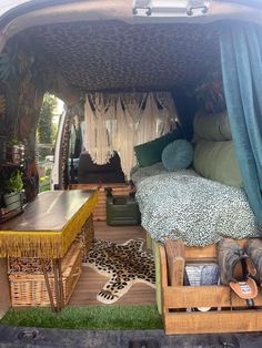 the inside of a van with an animal print rug and bed in it's back