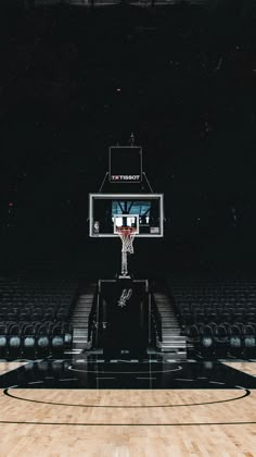 an empty basketball court with black seats