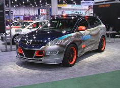 a car that is on display at an auto show with other cars in the background