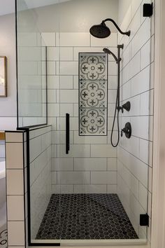 the shower is surrounded by black and white tile