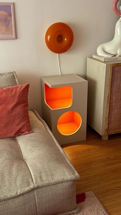 a living room with a couch, side table and lamp on the wall next to it