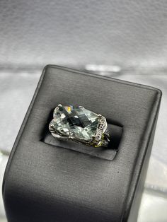 A dazzling 8 carat Blue Obsidian stone cut in a checkerboard pattern set with 75 pts of diamonds.  The ring is beautifully designed in 14 karat solid white gold with an ornate diamond setting throughout the outside of the ring. TDW:  0.75 cts Weight:  5.3 grams Size:  5 ½  Our Price $1500.00 Regularly Priced At $1900.00 Please See Our Video Remember - If you're purchasing for yourself or a gift for a loved one, buy with confidence.  We Guarantee Everything We Sell!  SKU # R948 Luxury Gemstones With Diamond Accents, Luxury Diamond Gemstones For Formal Occasions, Luxury Diamond Topaz Ring With Cushion Cut, Luxury Cushion Cut Diamond Topaz Ring, Luxury Diamond Cut Gemstones For Formal Occasions, Luxury Diamond Gemstones With Prong Setting, Luxury Topaz Ring With Diamond Accents, Fine Jewelry Diamond Gemstones With Diamond Cut, Fine Jewelry Diamond With Diamond Cut