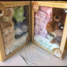 two boxes with stuffed animals in them on a table