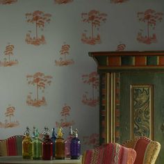 a dining room table and chairs in front of a wall with palm trees on it