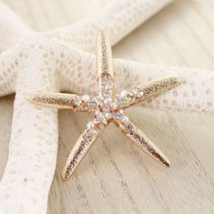 Gold tone starfish pendant featuring crystal and imitation pearl accents with a magnetic clasp. Measures approximately 2.25” in height. Luxury Ocean-inspired Jewelry With Starfish Charm, Luxury Starfish Charm Star Jewelry, Starfish Pendant, Magnetic Clasp, Starfish, Gold Tones, Crystals, Pendant, Gold