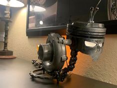 a motorcycle engine sitting on top of a wooden table next to a wall mounted clock