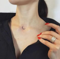 a woman with red nails and a crescent moon tattoo on her chest