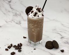 a chocolate milkshake with ice cream and oreo cookies on a marble table