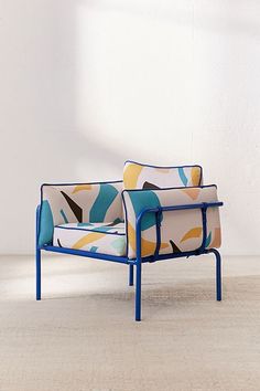 a blue and yellow chair sitting on top of a white floor next to a wall