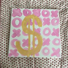 a pink and yellow painting on top of a polka dot bed spread with white sheets