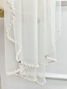 white sheer curtains with pearls hanging from them