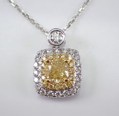 18K White Gold Cushion-cut Yellow Canary Diamond Pendant with Chain. This pendant is set with a natural Cushion cut Brilliant center Diamond. This Diamond is a fancy yellow canary color and weighs 1.01 carat. There are also sixteen natural Fancy Yellow Canary Round Diamonds and twenty-three round Brilliant white/colorless Diamonds set in this pendant. These diamonds are G/H color (white), SI clarity and weigh a total of .54 carat.  The total diamond weight of this necklace is 1.55 carats.  This Exquisite Gia Certified Necklaces For Wedding, Exquisite Gia Certified Wedding Necklaces, Dazzling Yellow Jewelry With Halo Setting, Yellow Diamond-cut Necklace In Fine Jewelry Style, Yellow Gold Gia Certified Necklace For Wedding, Yellow Diamond Cut Necklace In Fine Jewelry Style, Gia Certified Yellow Gold Necklace For Wedding, Yellow Fine Jewelry Necklace For Wedding, Yellow Pendant Jewelry For Formal Occasions