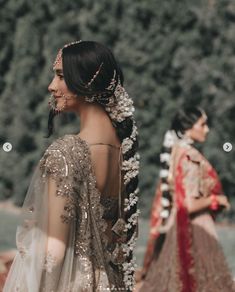 a woman in a bridal gown standing next to another woman