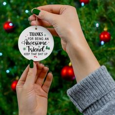 someone holding up a christmas ornament with the words thanks for being an awesome friend