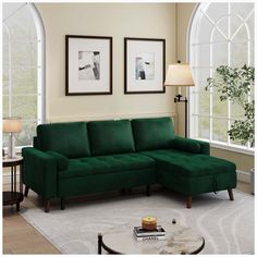 a living room with green couches and two tables in front of large arched windows