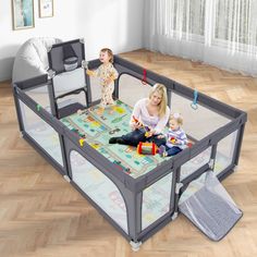 a woman and two children are playing in a playpen with the baby on it's lap