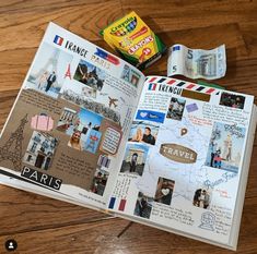 an open travel book on a wooden table with stickers and other items around it