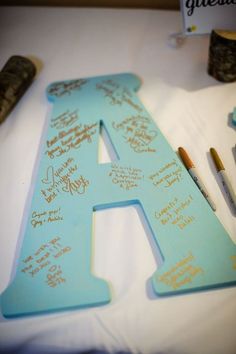 a large wooden letter with writing on it and some paintbrushes next to it