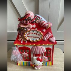 a hello kitty dollhouse with candy and candies on it's roof is shown