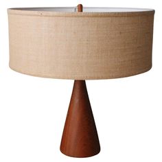 a wooden table lamp with a beige shade