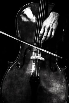 a close up of a person playing an instrument with their hand on the back of it