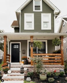 the front porch is decorated with plants and potted plants, along with pots on the steps