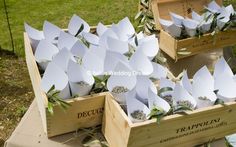 several wooden boxes filled with paper flowers on top of a table