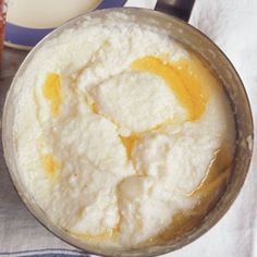 a pan filled with food sitting on top of a table next to a glass of milk