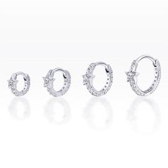 three pairs of earrings with diamonds on the bottom, and one is in white gold