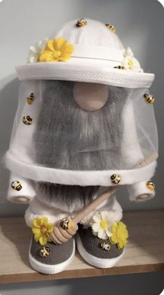 a stuffed animal wearing a white hat with flowers on it's head and holding a wooden stick