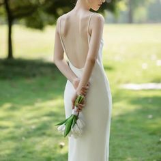 a woman in a white dress holding flowers