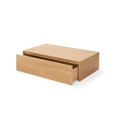 a wooden box sitting on top of a white floor next to a drawer with its lid open