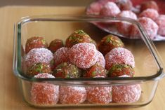 there are several desserts in the glass dishes on the table and one is covered with powdered sugar