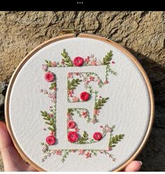 a hand embroidered monogram with flowers and the letter e in it's center