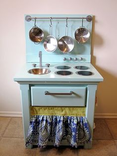 an old fashioned toy stove with pots and pans on it