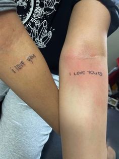 two people with arm tattoos that say i love you