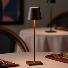 a lamp that is sitting on top of a table next to a fork and knife