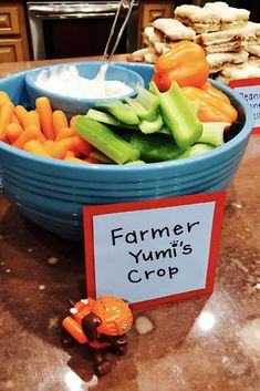 a bowl filled with carrots, celery and cucumbers next to crackers