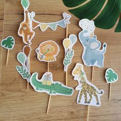 jungle animals and giraffes cupcake toppers on wooden sticks with green leaves