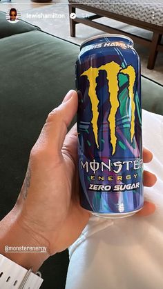 a person holding up a monster energy drink