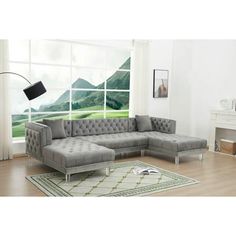 a living room with a gray sectional couch and white rug in front of a large window