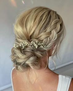 a woman with blonde hair and flowers in her hair is shown from the back view